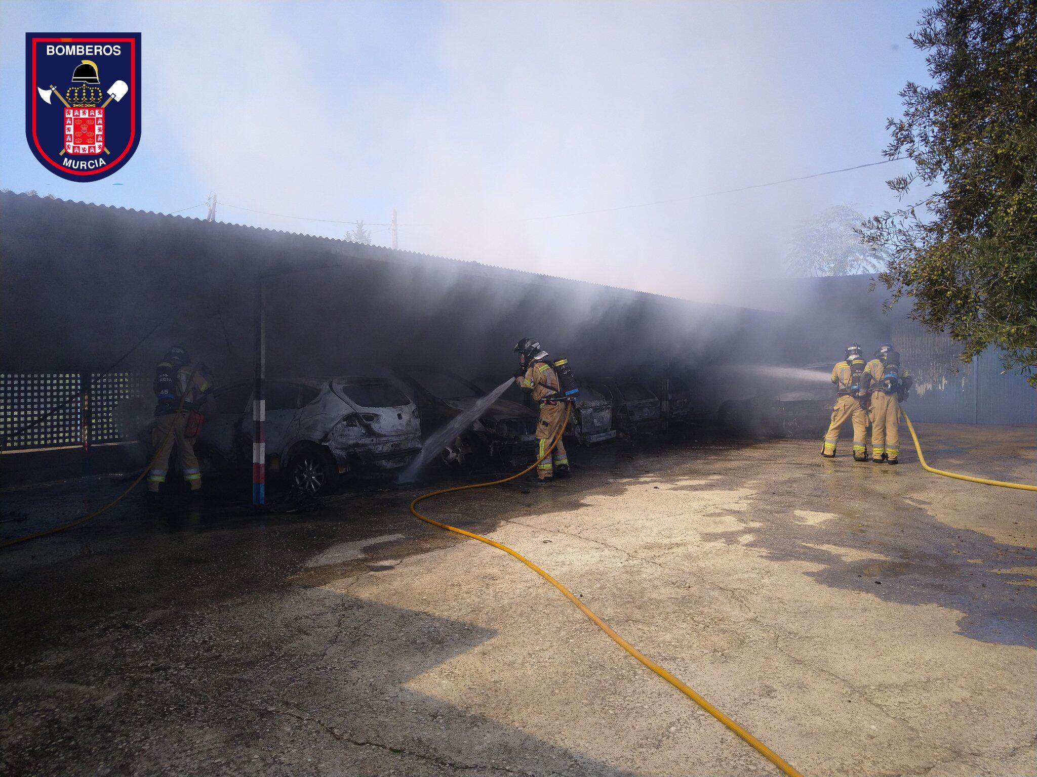Los bomberos sofocando el fuego que ha afectado a los vehículos