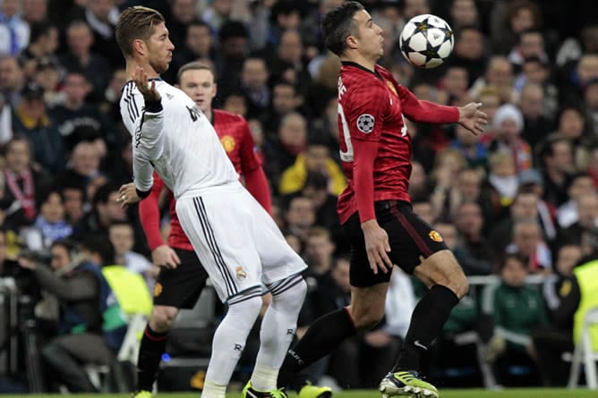 El defensa del Real Madrid Sergio Ramos (i) y el delantero del Manchester United Robin Van Persie (d), durante el partido de ida de los octavos de final de Liga de Campeones que ambos equipos disputan en el estadio Santiago Bernabéu