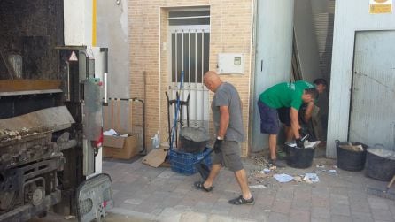 Operarios del Ayuntamiento de Gandia vaciando el local lleno de trastos y basura.