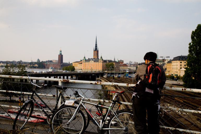 Un hombre junto a su bicicleta en uno de los canales de Estocolmo