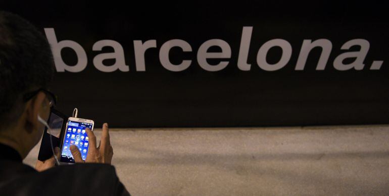 A visitor tests a phone during the 2015 Mobile World Congress (MWC) in Barcelona on March 4, 2015. Phone makers will seek to seduce new buyers with even smarter Internet-connected watches and other wireless gadgets as they wrestle for dominance at the world's biggest mobile fair. AFP PHOTO / LLUIS GENE