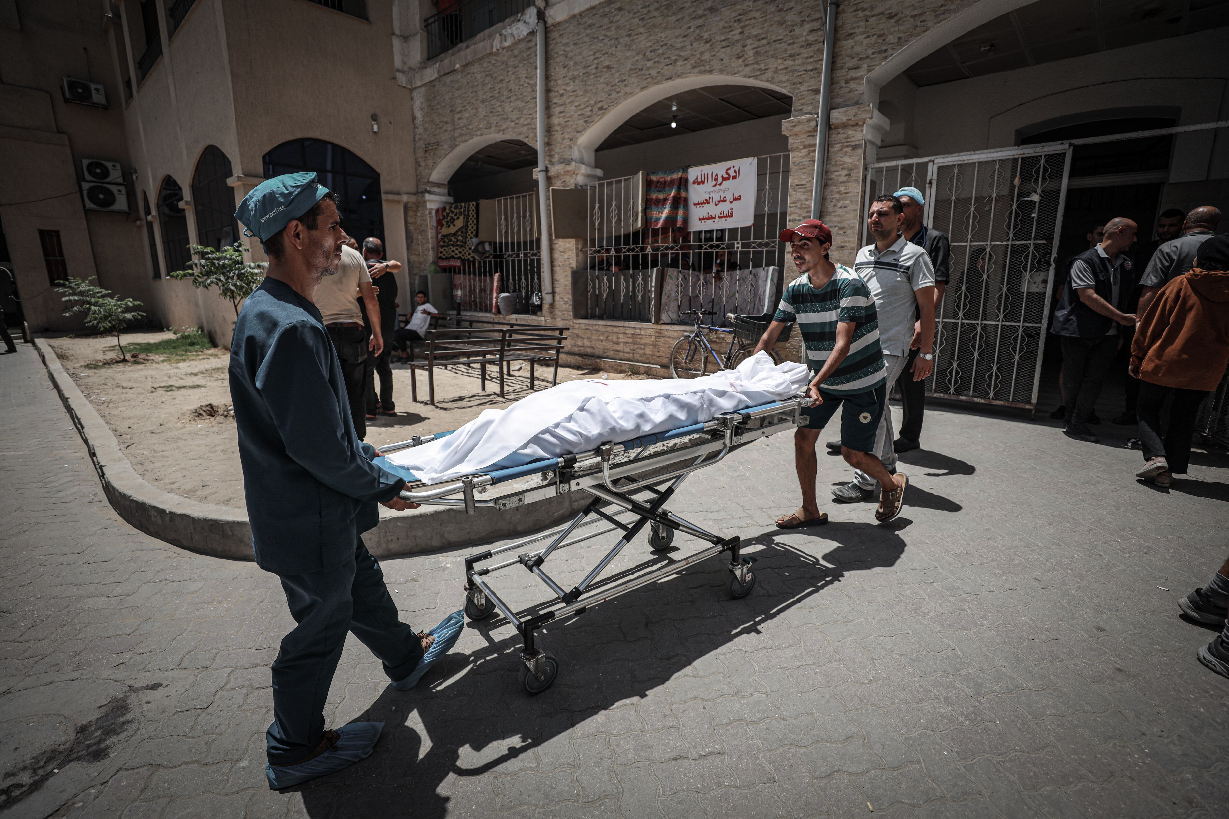 Varias personas trasladan los cuerpos de palestinos fallecidos tras el ataque sobre la única iglesia católica en Gaza.