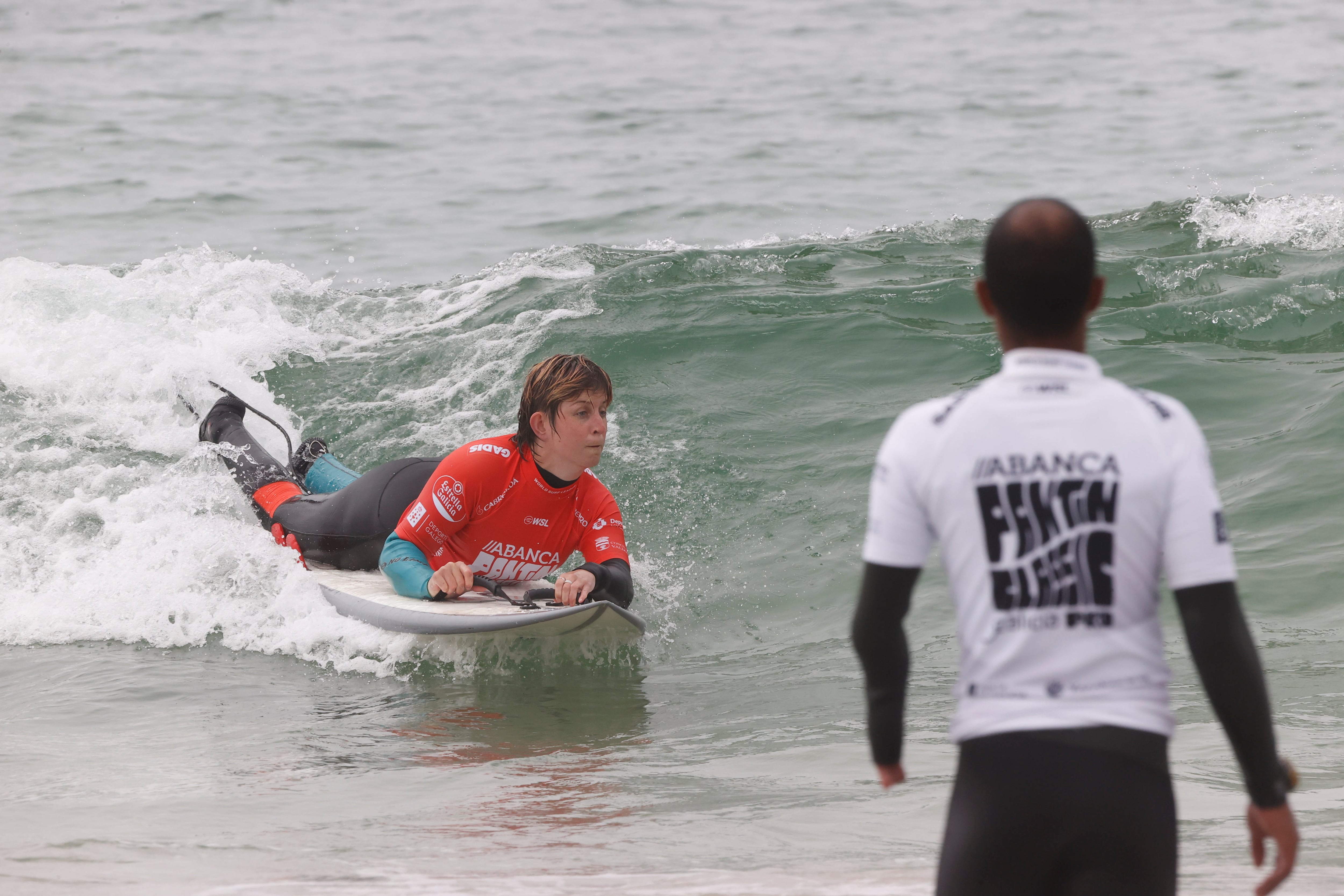 VALDOVIÑO, 11/07/2022.- La surfista Hanna Dines (i) compite en el Abanca Surf Adaptado, enmarcado dentro de la 35 edición del Abanca Pantín Classic Galicia Pro, y que cuenta con 30 surfistas de todo el mundo con diversidad funcional, este lunes en Valdoviño. EFE/ Kiko Delgado