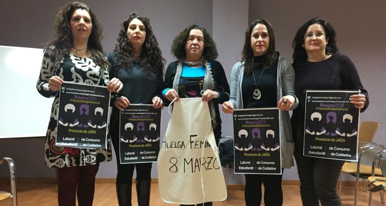 Integrantes del colectivo feminista con uno de los mandiles que serán colgados en los balcones y ventanas jiennenses.