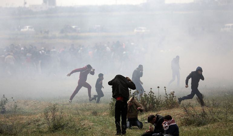 Varios palestinos huyen de gases lacrimógenos durante los enfrentamientos con soldados israelíes en el este de Beit Hanun, norte de la Franja de Gaza.