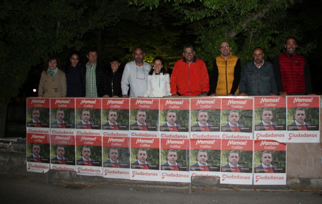 Los miembros de Ciudadanos Cuéllar, con David de las Heras cuarto por la derecha, ante los carteles de su candidato en la pegada de carteles.