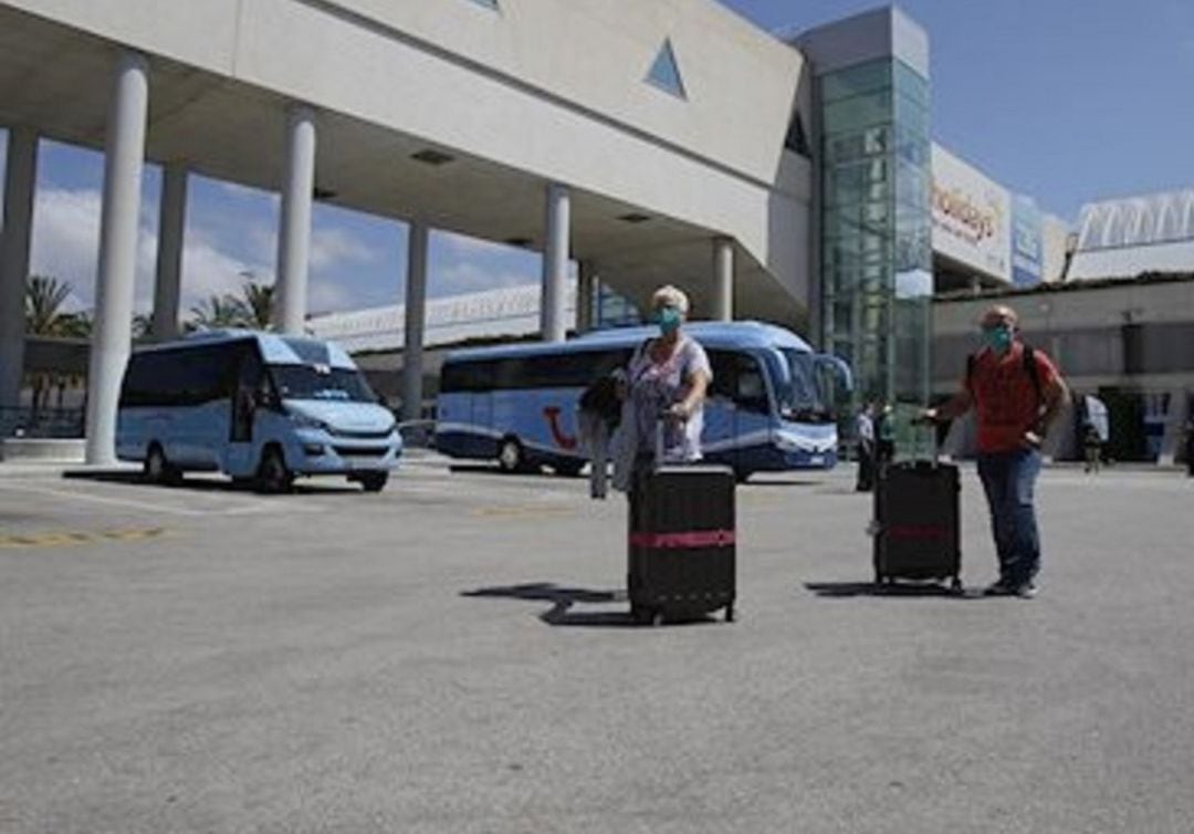 Pasajeros llevando sus maletas en el parquing de autobuses de Son Sant Joan