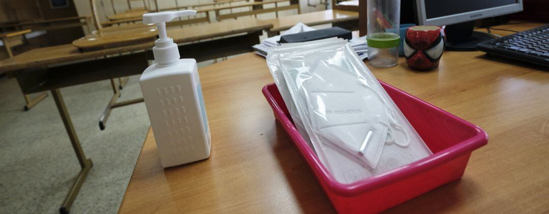 Archivo - Imagen de archivo de mascarillas y gel desinfectante en la mesa del profesor de un aula
