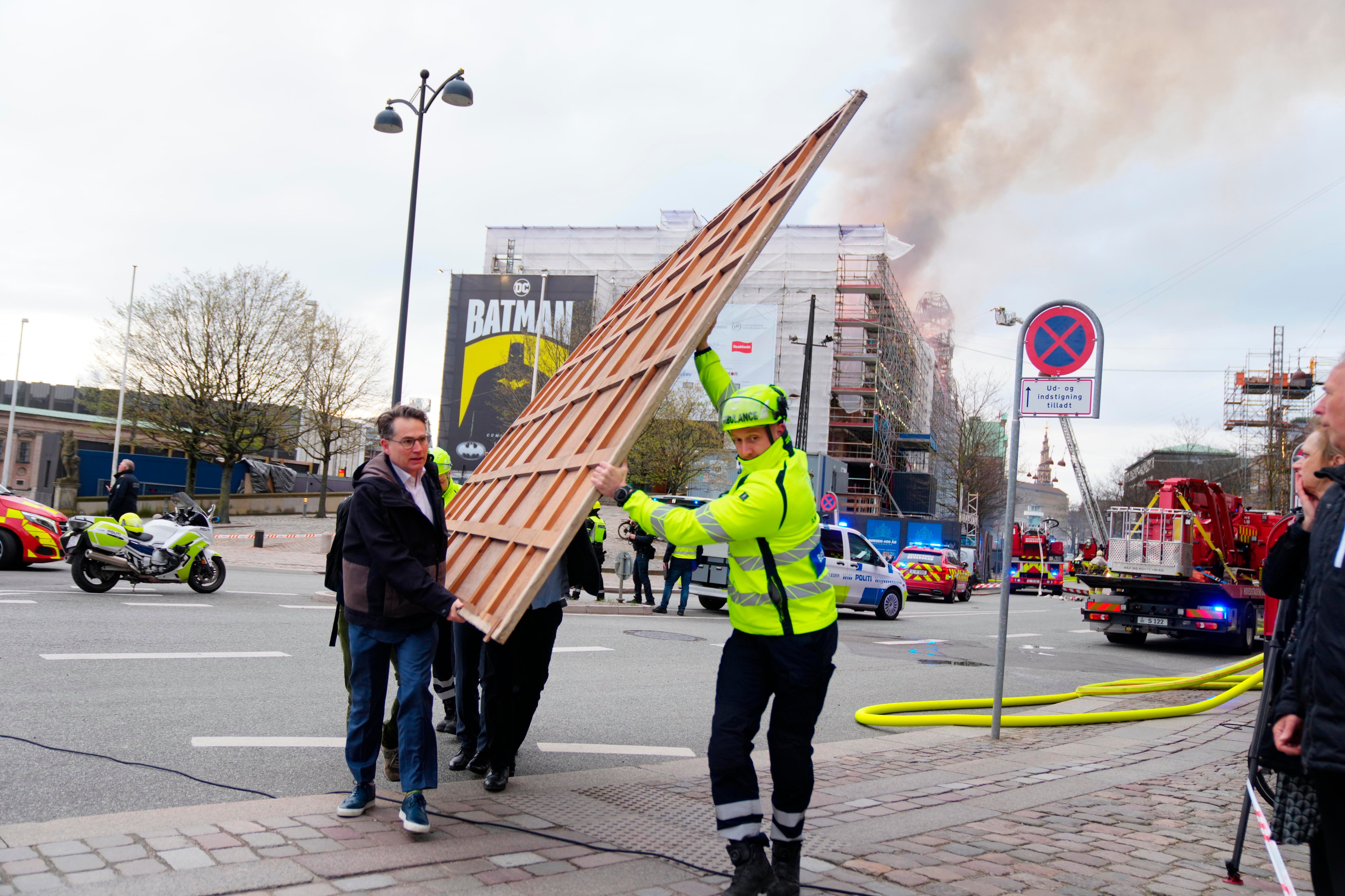 Un incendio arrasa el histórico edificio de la Bolsa de Copenhague y los trabajadores sacan cuadros del interior para salvarlos de la quema.