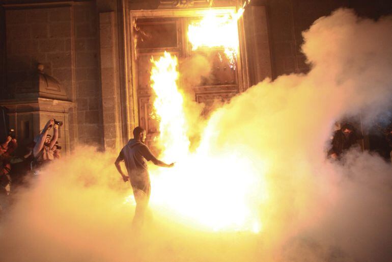 Una veintena de manifestantes escapuchados derribaron ayer las vallas de seguridad de los alrededores del Palacio Nacional, sede del Ejecutivo mexicano