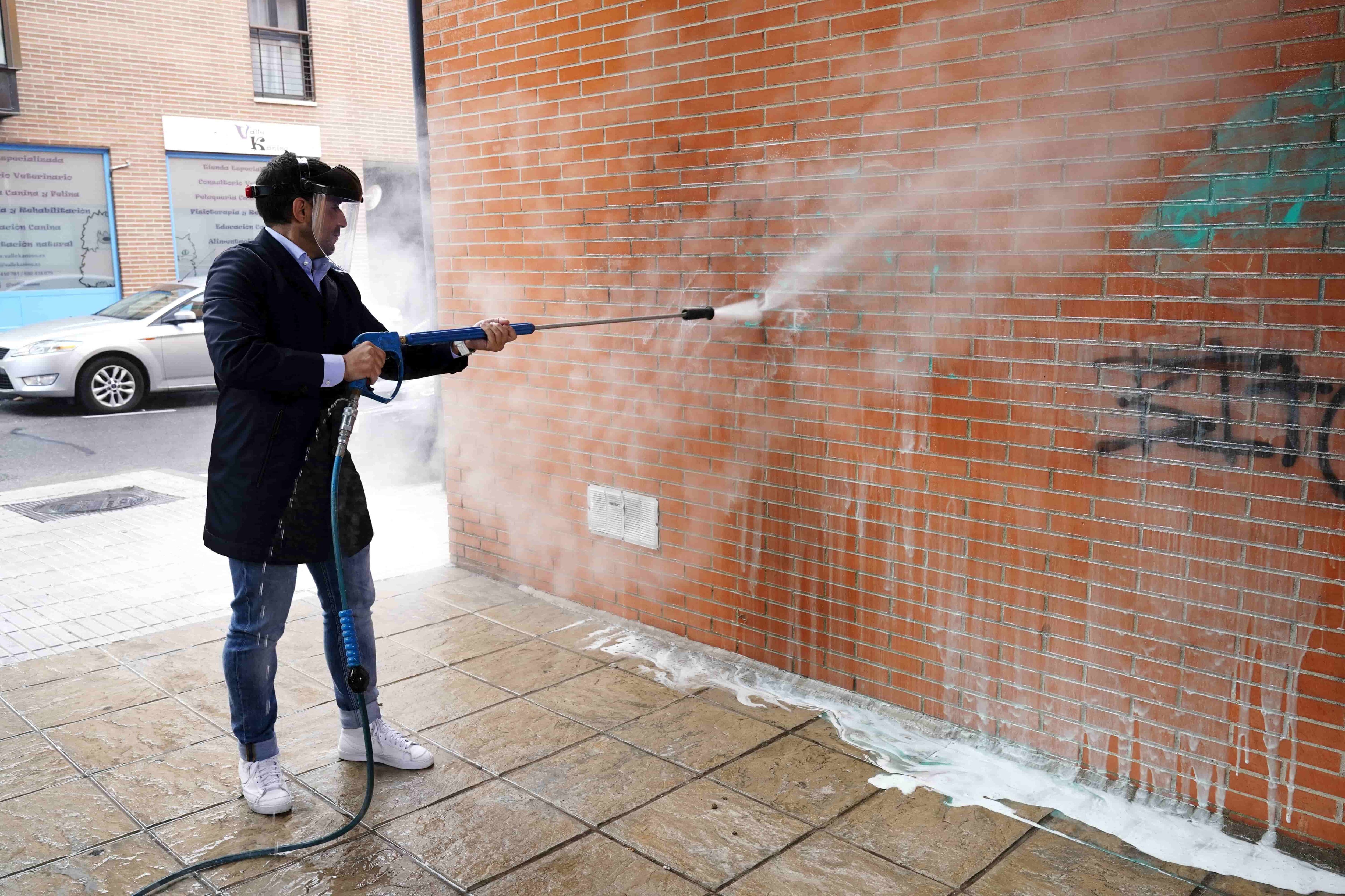 El vicealcalde de San Sebastián de los Reyes, Miguel Ángel Martín Perdiguero limpiando un grafiti en la plaza de Ciudad Real del municipio