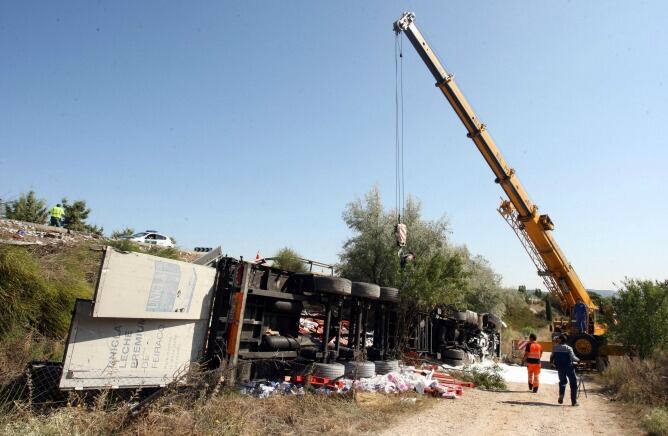 Tareas de rescate de uno de los camiones volcados tras la colisión de la N-122