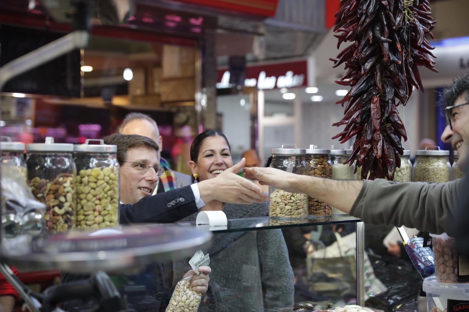 El alcalde de Madrid, José Luis Martínez-Almeida, saluda a un comerciante de un mercado de la capital