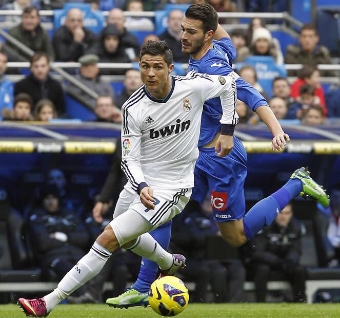 El delantero portugués del Real Madrid, Cristiano Ronaldo, se marcha del defensa del Getafe, Rafa López, durante el partido correspondiente a la vigésimo primera jornada de la Liga de fútbol de Primera División que los dos equipos disputaron en el estadio