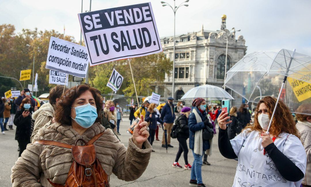 Una mujer sostiene una pancarta donde se lee &quot;Se vende tu salud&quot; durante una manifestación de la Marea Blanca en Madrid.