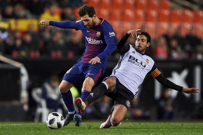 VALENCIA, SPAIN - FEBRUARY 08:  Daniel Parejo of Valencia CF competes for the ball with Lionel Messi of FC Barcelona during the Copa de Rey semi-final second leg match between Valencia and Barcelona on February 8, 2018 in Valencia, Spain.  (Photo by Manue