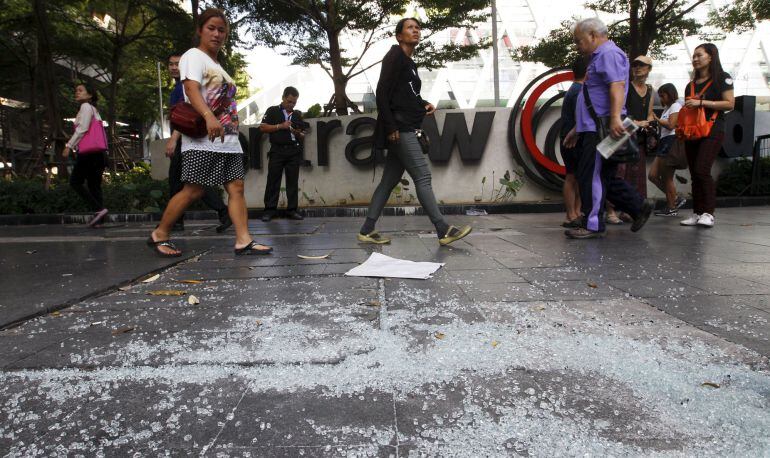 Ciudadanos de Bangkok caminan por el lugar del atentado. 