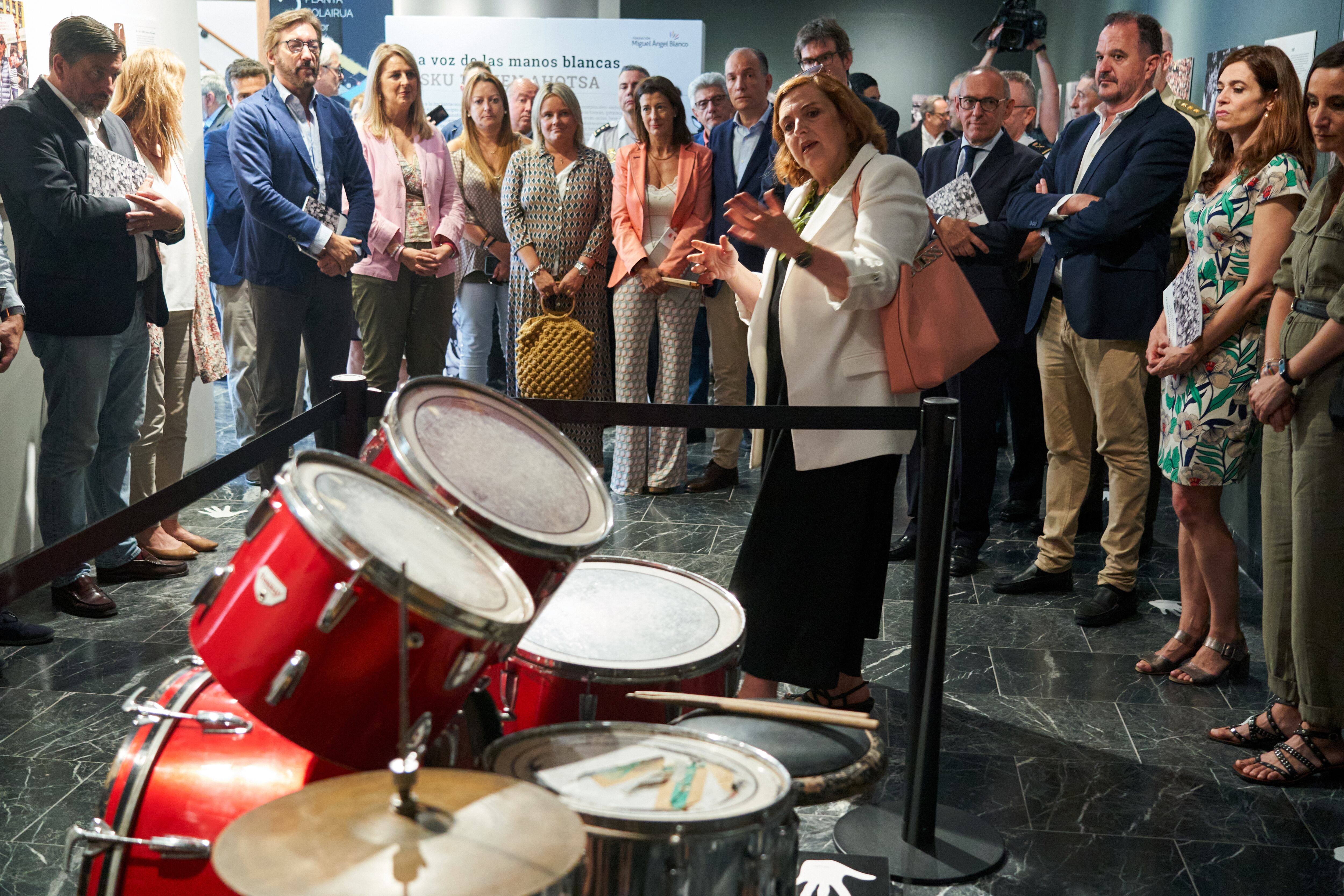 Mari Mar Blanco y representantes políticos e institucionales escuchan las explicaciones de Cristina Cuesta, directora de la Fundación, ante la batería de Miguel Ángel Blanco