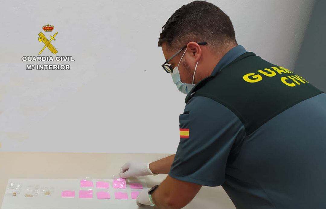 Imagen de un agente de la Guardia Civil con las sustancias intervenidas