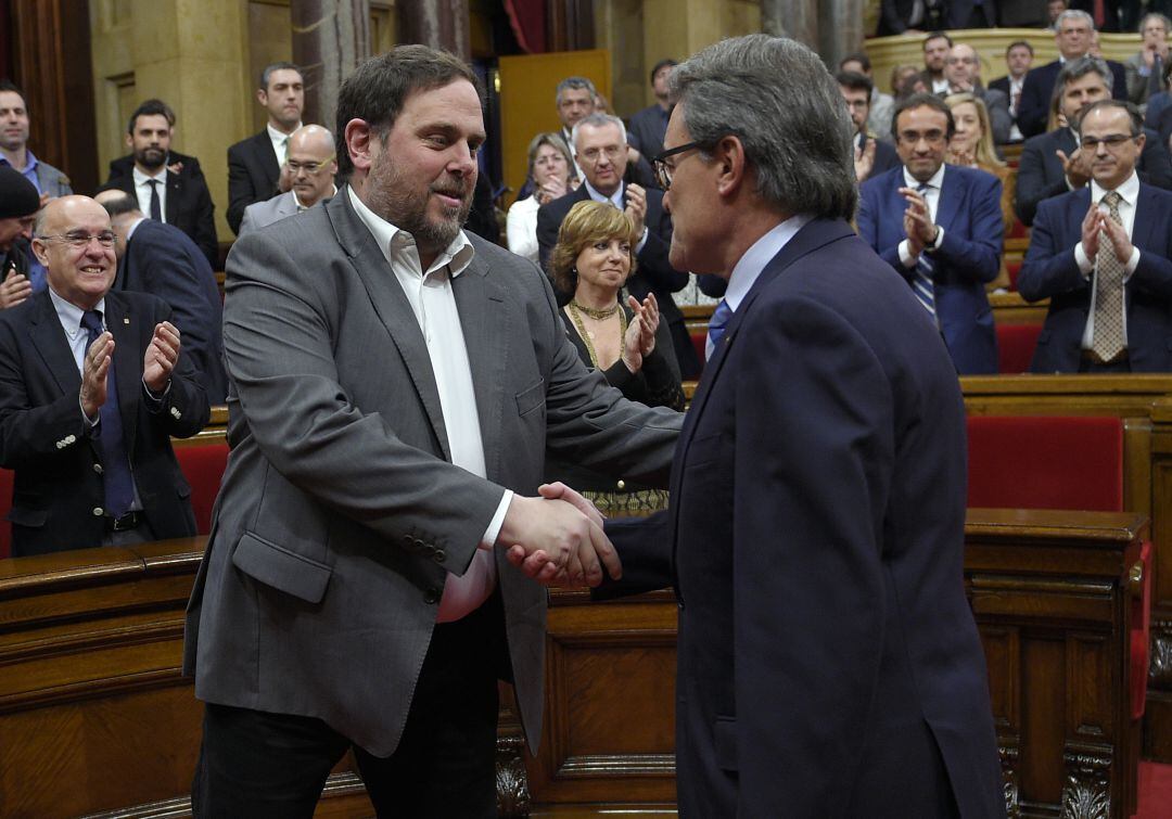 Artur Mas y Oriol Junqueras se estrechan la mano durante una sesión del Parlament.