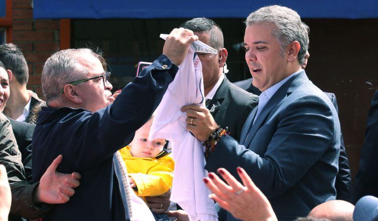 El candidato presidencial Iván Duque (d) saluda a sus simpatizantes a su llegada a su puesto de votación en Bogotá (Colombia).