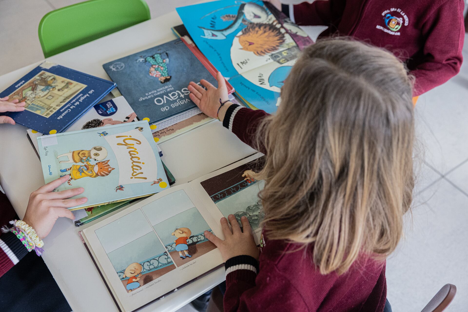 Imagen de una niña observando diferentes libros en una biblioteca