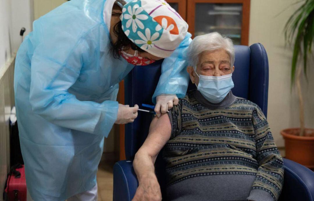Una sanitaria administra la vacuna contra el coronavirus a una mujer mayor de 80 años