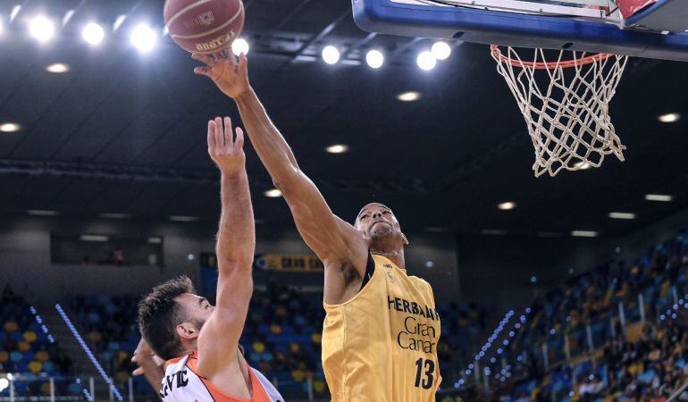 El ala pívot del Herbalife Gran Canaria Eulis Báez (d), tapona el lanzamiento del escolta bosnio del Montakit Fuenlabrada, Marko Popovic (i), durante el partido perteneciente a la jornada número 33 de la Liga ACB. 