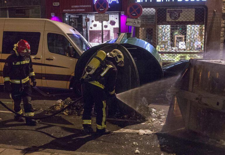 GRA424. VITORIA, 03/03/2015.- Los bomberos apagan un contenedor volcado e incendiado durante los incidentes que se han producido hoy al término de una manifestación en memoria de los cinco trabajadores que murieron por disparos de la Policía hace 39 años en Vitoria. La manifestación en recuerdo de los trabajadores fallecidos el 3 de marzo de 1976 ha concluido con incidentes en el casco viejo de la capital alavesa. EFE/David Aguilar