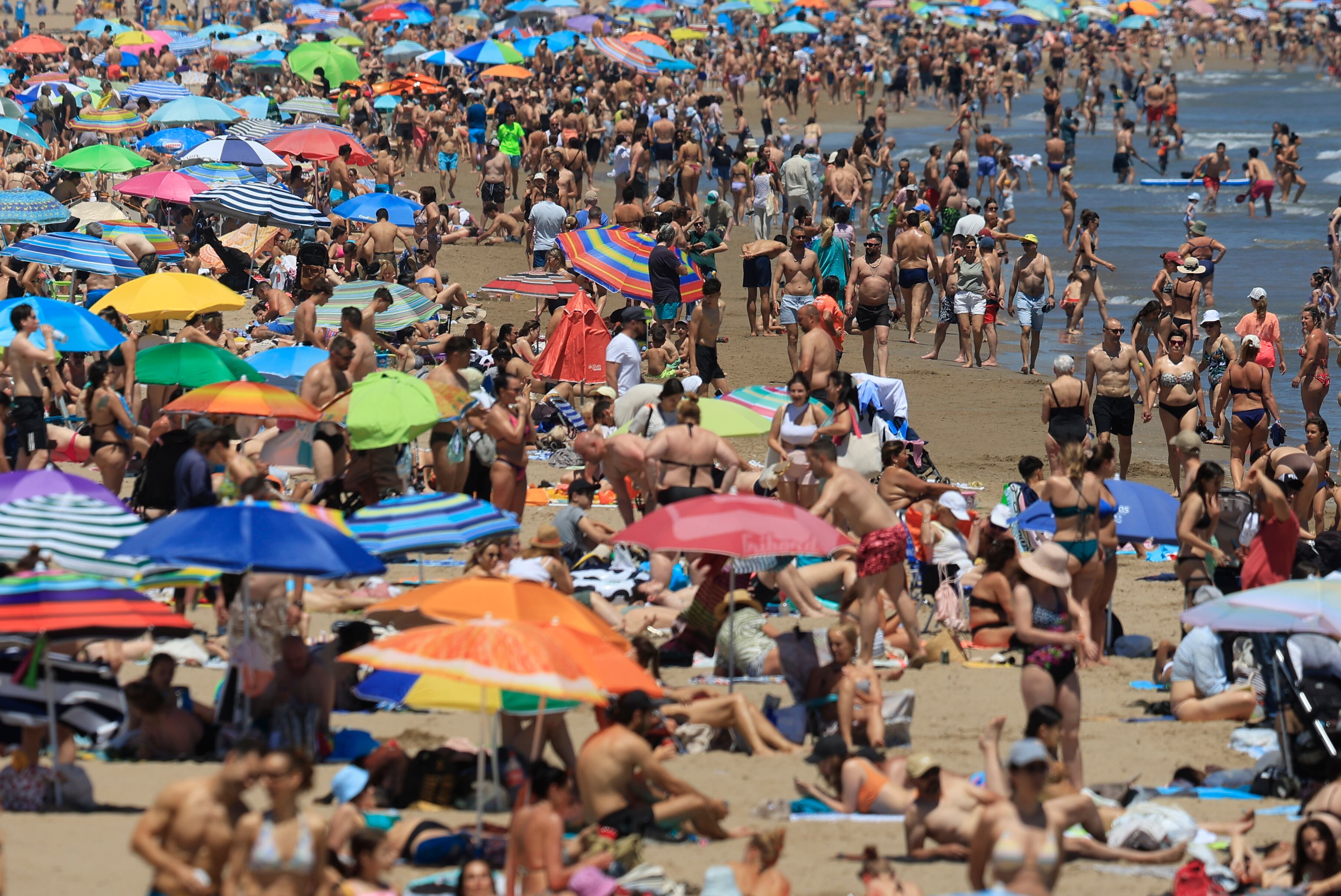 Cientos de personas se han acercado a la playa de la Malvarrosa de Valencia, para disfrutar de las altas temperaturas registradas este domingo. EFE/ Kai Forsterling