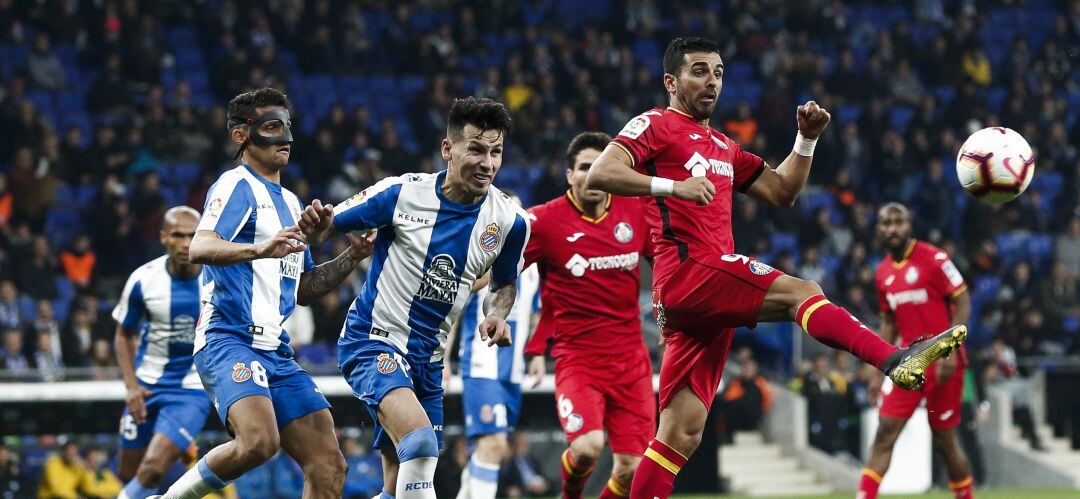 El jugador del Getafe C.F. Angel (d) intenta controlar el balón ante la oposición del &#039;perico&#039; Hernán Pérez.