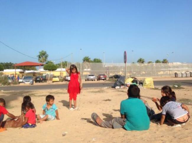 Niños sirios juegan al atardecer en la puerta del Centro de Estancia Temporal de Inmigrantes de Melilla que, con 1.700 internos, está al triple de su capacidad