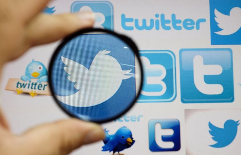 A person holds a magnifying glass over a computer screen displaying Twitter logos, in this picture illustration taken in Skopje September 10, 2013.  REUTERS/Ognen Teofilovski (MACEDONIA) - RTX14KXO