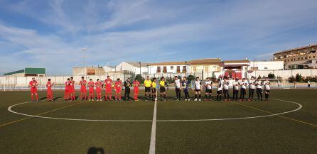 Los dos equipos y el trío arbitral en el saludo inicial