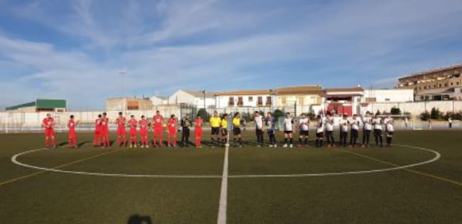 Los dos equipos y el trío arbitral en el saludo inicial