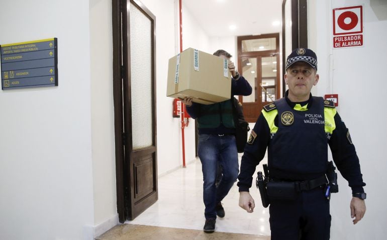 Un agente de la Guardia Civil lleva una caja con el material incautado en el registro de las oficinas del grupo municipal del PP, que han sido registradas por agentes de la Benemérita y un fiscal anticorrupción.