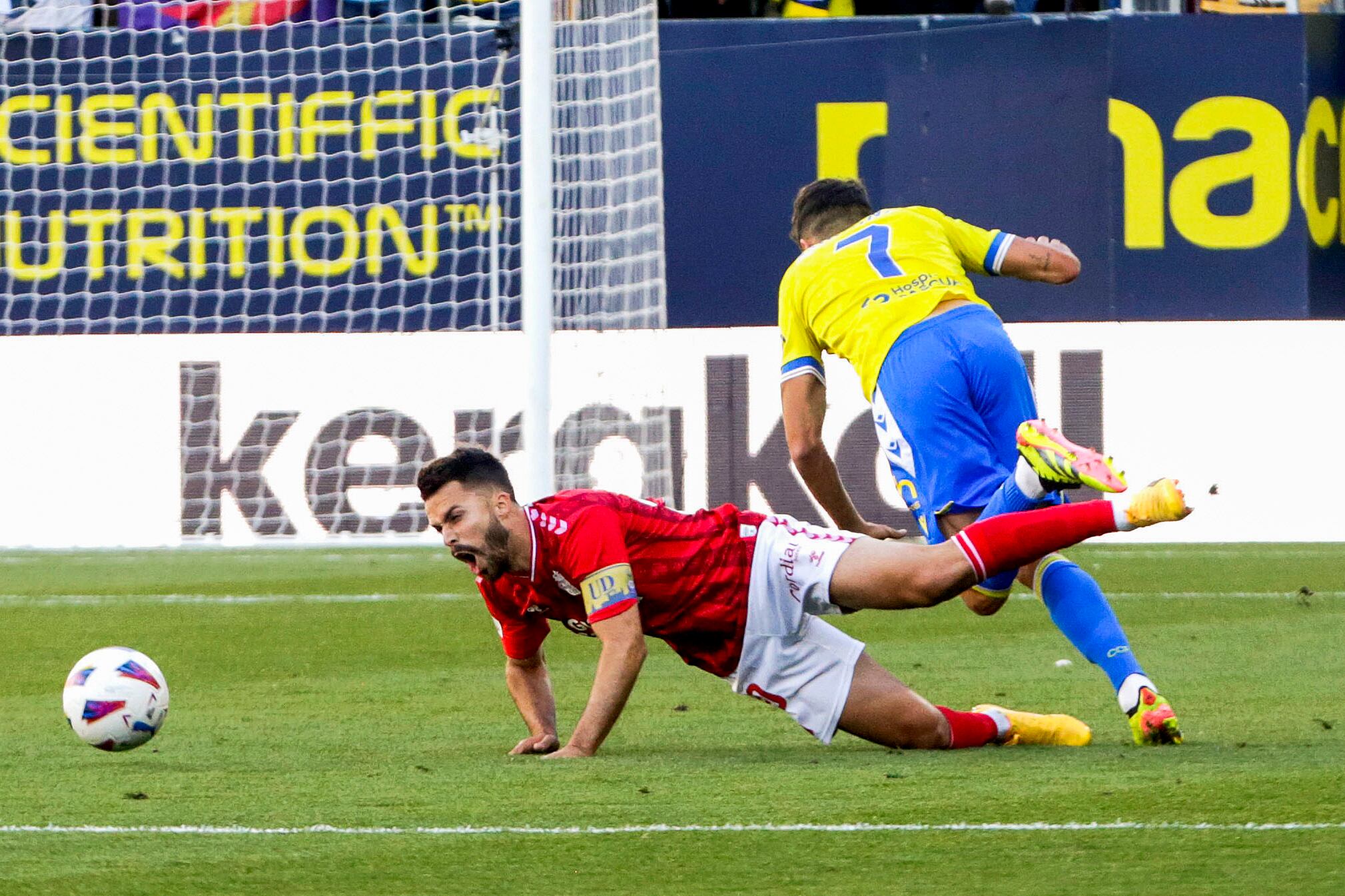 CÁDIZ, 19/05/2024. El centrocampista de UD Las Palmas, Kirian, cae ante el delantero del Cádiz, Rubén Sobrino, durante el encuentro correspondiente a la jornada 37 de Primera División que Cádiz y Las Palmas disputan hoy Domingo en el estadio Nuevo Mirandilla de la capital gaditana. EFE/Román Ríos.
