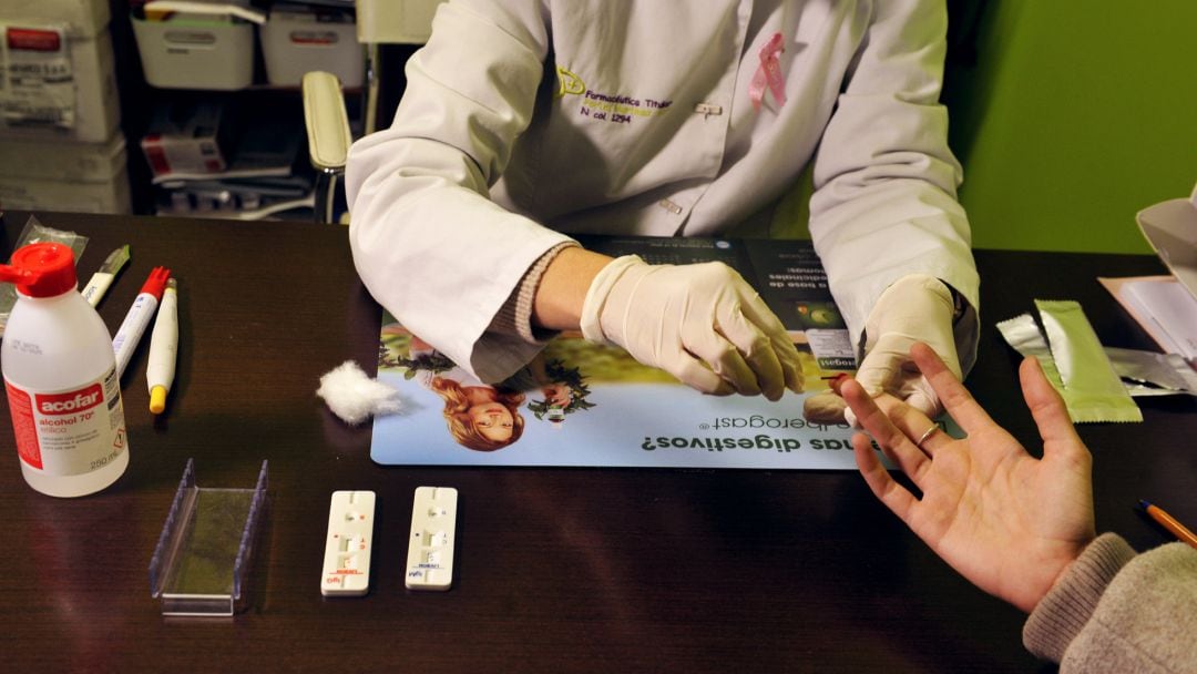 Una farmacéutica toma una muestra de sangre para realizar un test de coronavirus.