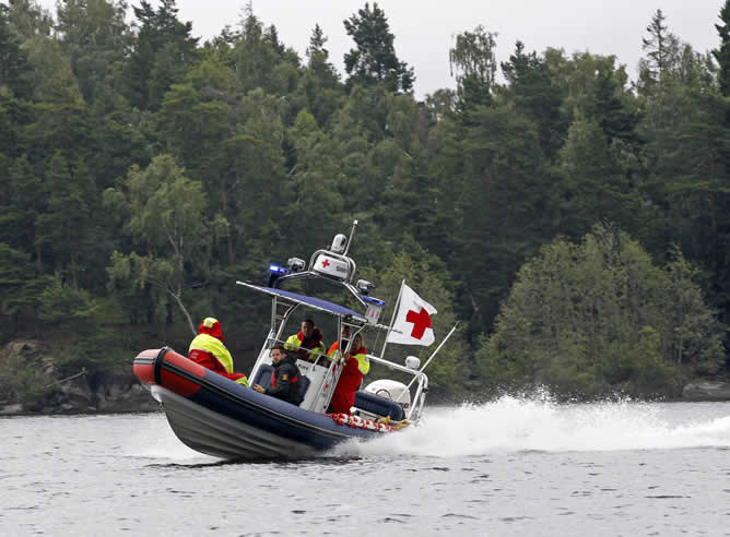 Una lancha de la Cruz Roja navega por la orilla de la pequeña isla de Utøya para evitar que los medios de comunicación se acerquen al lugar en el que se produjo el atentado.