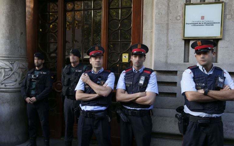 Agentes de la Guardia Civil y de los Mossos d&#039;Esquadra en la puerta de la consellería de Economía de la Generalitat esta mañana. 