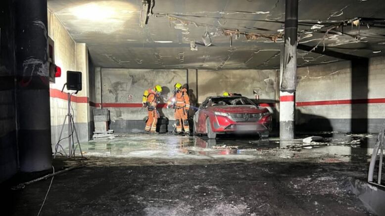 Los bomberos trabajan en el interior del garaje de Albaida durante la extinción del incendio del vehículo híbrido enchufable