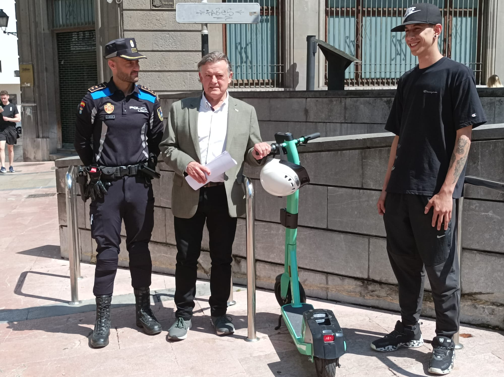 El concejal de Seguridad Ciudadana, José Ramón Prado; el Inspector de la Policía Local, Diego Cortina; y un empleado de la empresa de alquiler de patinetes en un punto de estacionamiento de estos vehículos eléctricos.