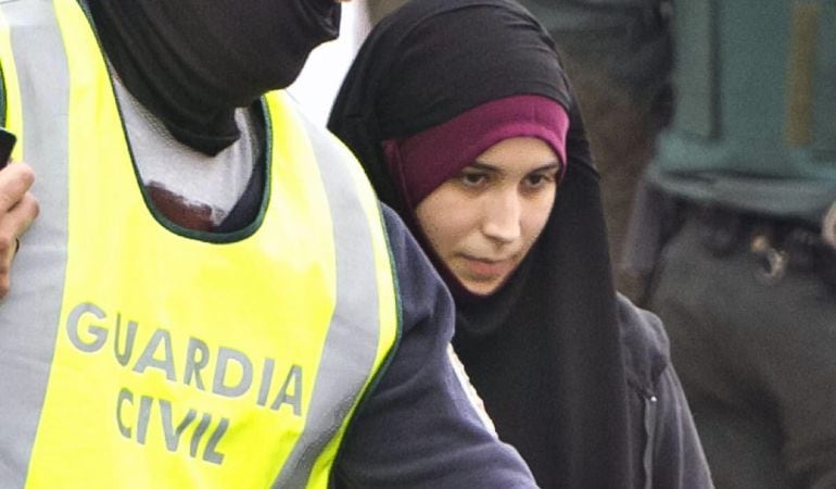 -FOTODELDIA- GRA256. ALMONTE (HUELVA), 20/10/2015.- La joven onubense de 22 años detenida esta madrugada en el aeropuerto de Madrid-Barajas cuando intentaba viajar a Turquia para trasladarse después a Siria e integrarse en el Estado Islámico, es acompañada por agentes de la Guardia Civil tras dar por concluido el registro de su domicilio en Almonte (Huelva).- EFE / Julián Pérez