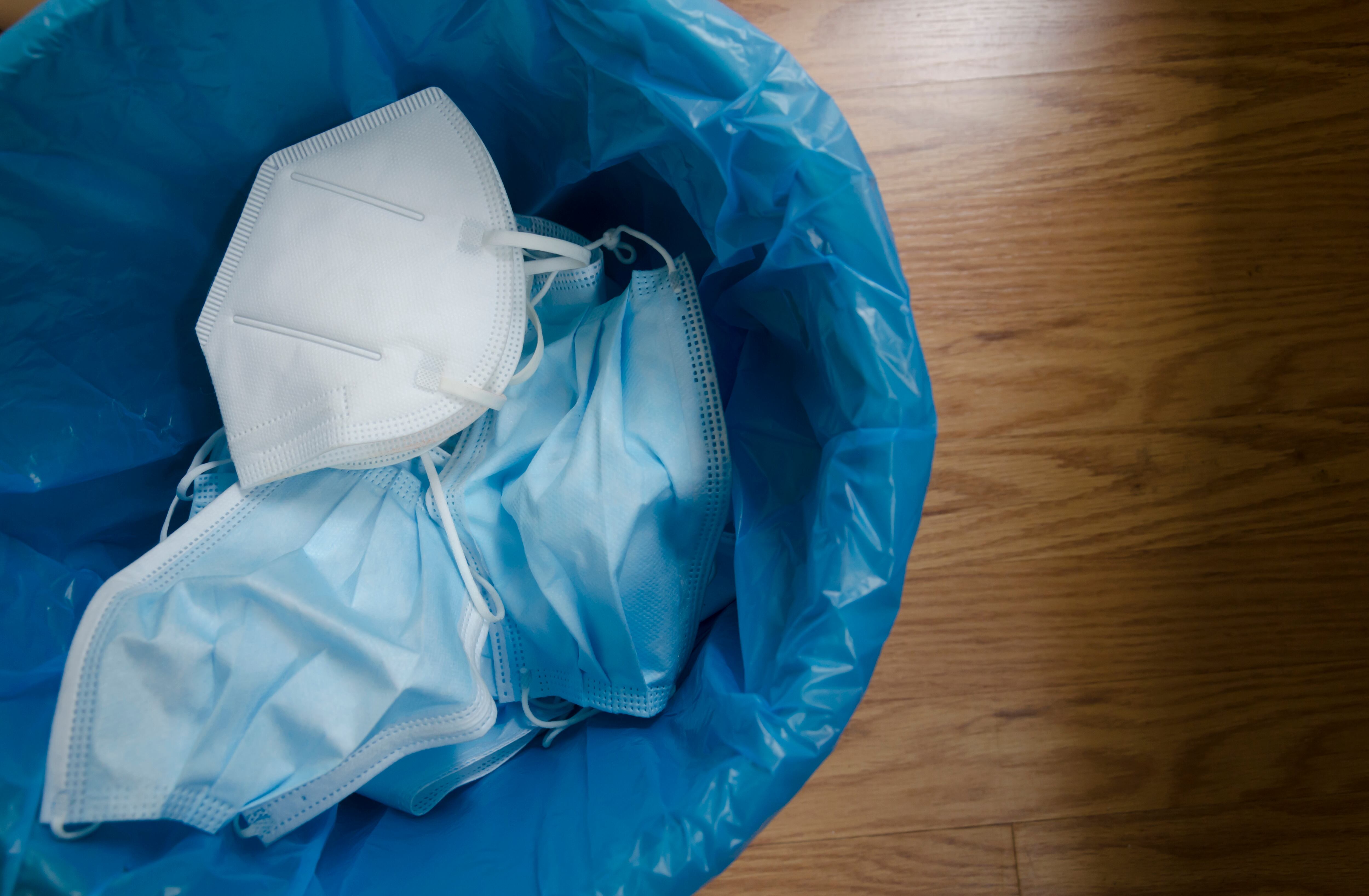 Varias mascarillas tiradas a la basura para poder ser recicladas