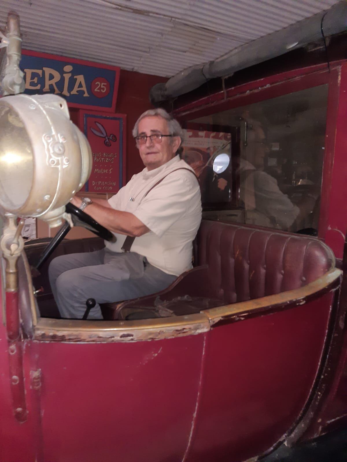 Vicente Pavía sobre uno de los coches de época de su colección