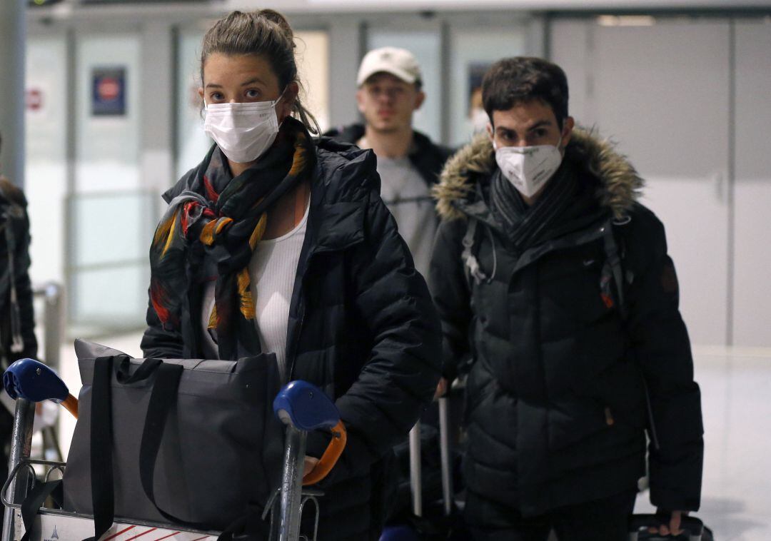 PARIS, FRANCE - FEBRUARY 10: Passengers coming from China wearing protective masks leave the terminal after landing in Charles De Gaulle Airport on February 