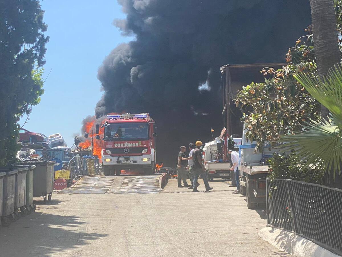 Efectivos de bomberos trabajan para sofocar el incendio en el desguace de Los Ruices en Málaga