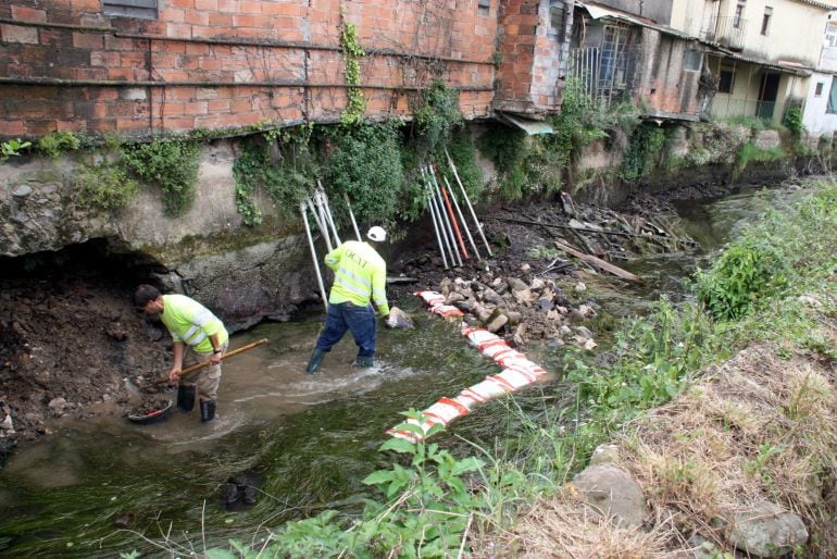 Obras en la ribera de un río español que muestra un pésimo estado como consecuencia de la sequía y la contaminación del agua.
 