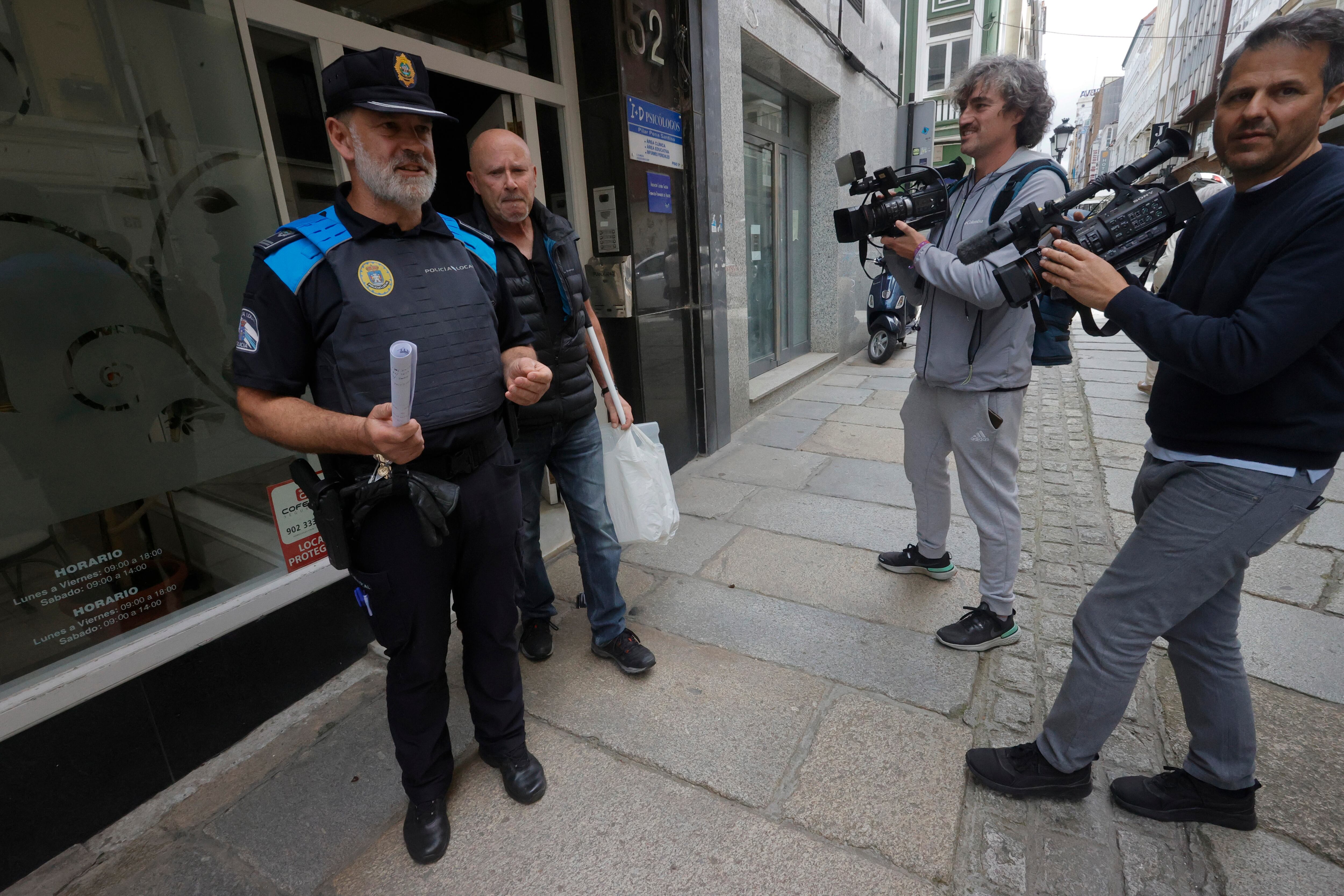 FERROL, 15/05/2023.- Efectivos de la policía local acompañados de un especialista en serpientes (2i) buscan en un edificio de Ferrol una Boa que se dio por perdida hace varios días en ferrol , y es donde reside su dueño, hoy por la mañana no pudo realizarse la búsqueda en la propia vivienda por que no estaba el propietario. En las imágenes el técnico en serpientes y el inspector de la policía local durante la búsqueda realizada en la peluquería que está en el bajo del edificio. EFE/Kiko Delgado