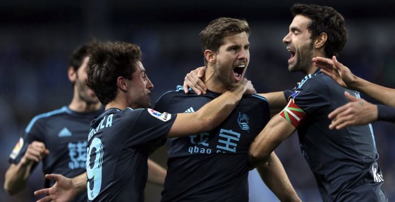 Los jugadores de la Real Sociedad, Iñigo Martínez (c), Álvaro Odriozola (i) y Xabi Prieto, celebran un gol en su victoria contra el Málaga.